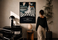 White Off-White Nike Air Force 1 print in a black frame on a sunlit plaster wall, a person looking on beside a mushroom lamp