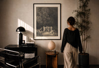 Dore Assembly of the Poets print in a black frame on a sunlit plaster wall, a woman looking on beside a mushroom lamp