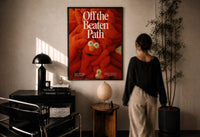Off the Beaten Path KAWS-Inspired Red Plush print in a black frame on a sunlit wall with a viewer
