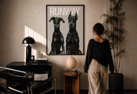 Doberman Pinscher Portrait Duo print in a black frame on a sunlit plaster wall, a person looking on beside a mushroom lamp