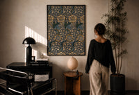 William Morris Kennet print in a black frame on a sunlit plaster wall, a woman looking on beside a mushroom lamp