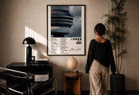 Drake Views CN Tower Tracklist print in a black frame on a sunlit plaster wall, a person looking on beside a mushroom lamp