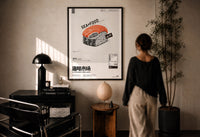 SEAxFOOD Market Original Salmon Sushi print in a black frame on a sunlit wall with a viewer