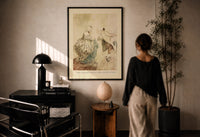 Arthur Rackham Fezziwig's Dance print in a black frame on a sunlit plaster wall, a woman looking on beside a mushroom lamp