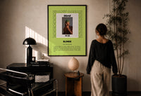 Frank Ocean Blonde Album Cover print in a black frame on a sunlit plaster wall, a person looking on beside a mushroom lamp