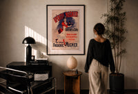 Aperitif Mugnier Cafe print in a black frame on a sunlit plaster wall, a woman looking on beside a mushroom lamp