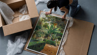 garden with palm trees and figures vintage art print framed print being unpacked from protective bubble wrap and a box