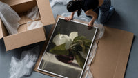 white peony in dark glass vase vintage art print framed print being unpacked from protective bubble wrap and a box