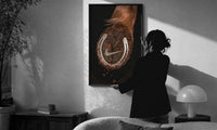 Nike Horse Hoof Swoosh Equestrian print in a slim black frame being hung on a sunlit wall in a monochrome room