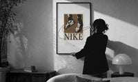 Nike Air Force 1 Streetwear print in a slim black frame being hung on a sunlit wall in a monochrome room