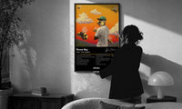 Tyler the Creator Flower Boy Tracklist print in a slim black frame being hung on a sunlit wall in a monochrome room