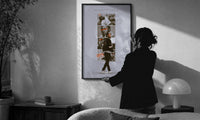 Kendrick Lamar DAMN Collage print in a slim black frame being hung on a sunlit wall in a monochrome room