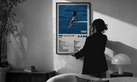 SZA SOS Album Tracklist print in a slim black frame being hung on a sunlit wall in a monochrome room
