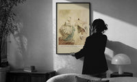 Arthur Rackham Fezziwig's Dance print in a slim black frame being hung on a sunlit wall in a monochrome room
