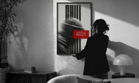 Hypebeast Motivational Portrait Glitch print in a slim black frame being hung on a sunlit wall in a monochrome room
