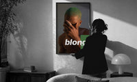 Blond Frank Ocean Album Cover Portrait print in a slim black frame being hung on a sunlit wall in a monochrome room