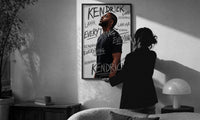 Kendrick Lamar Everything Profile print in a slim black frame being hung on a sunlit wall in a monochrome room