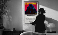 The Weeknd Starboy Album Cover print in a slim black frame being hung on a sunlit wall in a monochrome room