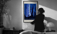 WPA See America Caverns print in a slim black frame being hung on a sunlit wall in a monochrome room