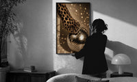 Cheetah Paw and Disco Ball print in a slim black frame being hung on a sunlit wall in a monochrome room