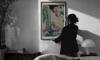Hokusai Ono Waterfall Kiso Road print in a slim black frame being hung on a sunlit wall in a monochrome room