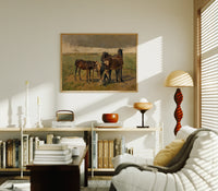 Group of horses in field print in an oak frame above a mid-century book console with a vintage radio