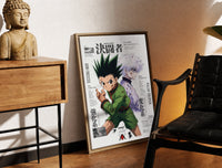 Brass-framed Gon and Killua anime characters print leaning in a warm styled corner by a sculpture