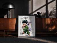 Black-framed Gon and Killua anime characters print on a moody console with designer coffee-table books