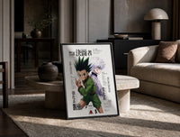 Gon and Killua anime characters print in a black frame leaning on a travertine table in a sunlit lounge