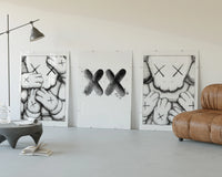 KAWS XX Outline Sketch Wall Art Set of 3 displayed beside a brown leather sofa