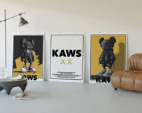 KAWS Monogram Impact Hypebeast Wall Art Set of 3 displayed beside a brown leather sofa