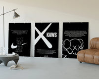 KAWS Monochrome Wall Art Set three-panel set displayed beside a brown leather sofa