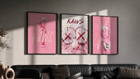 Bubblegum Pink KAWS XX Hypebeast Wall Art Set of 3 in black frames on a grey wall above a leather sofa