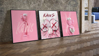 Bubblegum Pink KAWS XX Hypebeast Wall Art Set of 3 leaning on parquet beside a vintage loft door