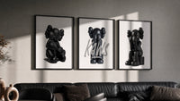 Blackout XX KAWS Hypebeast Wall Art Set of 3 in black frames on a grey wall above a leather sofa