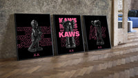 Neon Pink Noir KAWS Hypebeast XX Wall Art Set of 3 leaning on parquet beside a vintage loft door