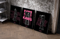 Neon Pink Noir KAWS Hypebeast XX Wall Art Set of 3 as black-framed prints leaning against a raw-plaster wall