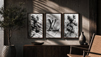 KAWS LV Monochrome Splash XX Wall Art Set of 3 in walnut frames above a sideboard in a warm room
