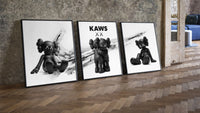 KAWS x Nike Blackout Poster Set of 3 leaning on parquet beside a vintage loft door