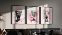 Pink KAWS Companion Triptych in black frames on a grey wall above a leather sofa