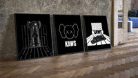 KAWS Monochrome Statement three-piece set leaning on parquet beside a vintage loft door
