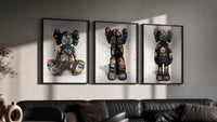 KAWS Companion Graffiti Triptych in black frames on a grey wall above a leather sofa