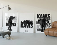 KAWS Legacy Archive three-panel set displayed beside a brown leather sofa