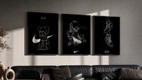 KAWS Companion x Nike Swoosh Sketch Triptych in black frames on a grey wall above a leather sofa