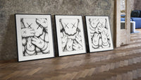 KAWS XX Crosshatch Triptych leaning on parquet beside a vintage loft door