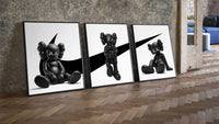 KAWS x Nike Monochrome Companion Triptych leaning on parquet beside a vintage loft door