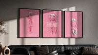Pink Cotton Candy KAWS Friends Trio in black frames on a grey wall above a leather sofa