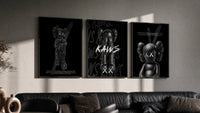 KAWS Companion Black Poster Set triptych in three black frames on a grey wall above a leather sofa