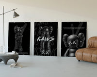 KAWS Companion Black Poster Set three-panel set displayed beside a brown leather sofa