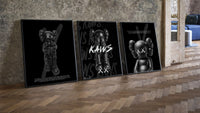 KAWS Companion Black Poster Set three-piece set leaning on parquet beside a vintage loft door